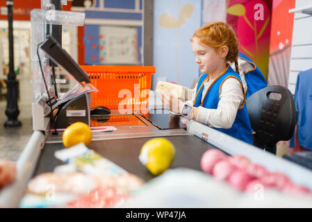 Girl in uniform at the register playing seller Stock Photo