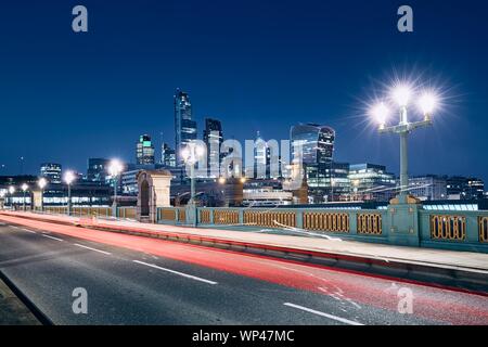 Light trail of car on bridge against illuminated urban skyline. London, United Kingdom Stock Photo