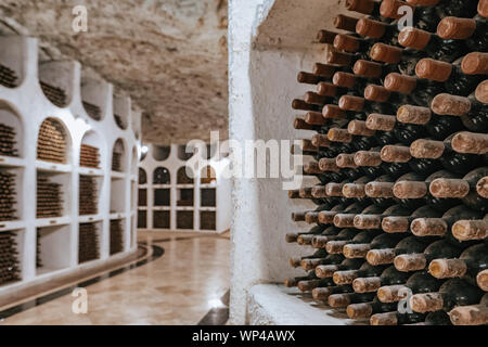 Wine bottles stacked up in old wine cellar close-up Stock Photo