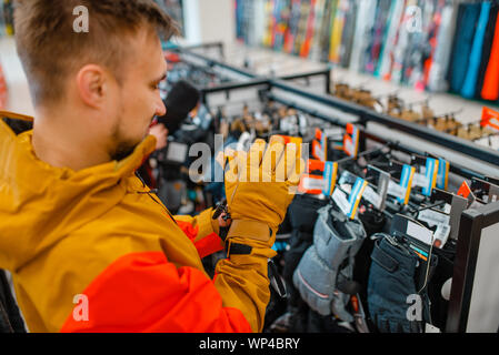 Man trying on gloves for ski or snowboarding Stock Photo