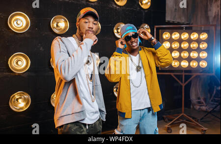 Two black rappers in caps on stage with spotlights Stock Photo