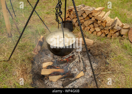 Cauldron with cooking soup on a campfire. Stock Photo