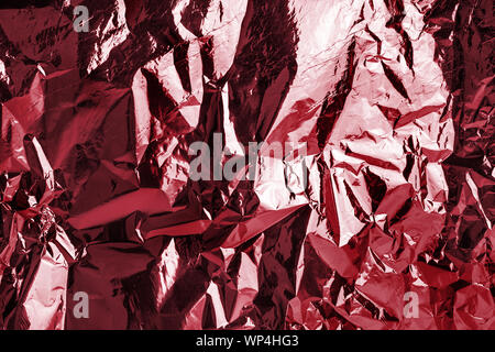 Dark pink shiny metallic crumpled texture effect, red wrinkled soft silky background, festive fashion purple glossy art backdrop, abstract pattern Stock Photo