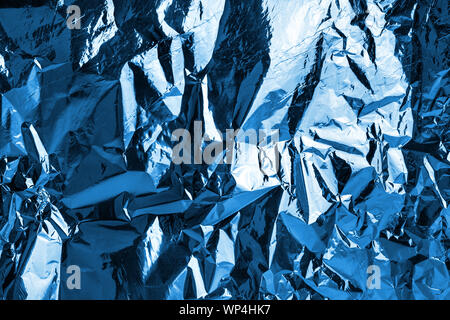 Crumpled blue foil shining texture background, bright shiny cold icy design, metallic glitter surface, winter holidays decoration backdrop concept Stock Photo