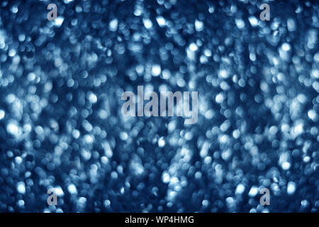 Blurred dark blue shiny glitter bokeh background, defocused soft blue silver shimmer festive backdrop design, white shining round bubbles blur effect Stock Photo