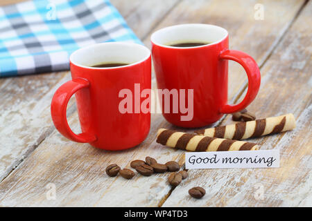 Good morning card with two red coffee mugs and crunchy wafers on rustic wooden surface Stock Photo