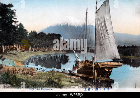 [ 1910s Japan - Japanese Sailing Vessel and Mount Fuji ] —   A view of Numakawa River and Mount Fuji as seen from Tagonoura in Shizuoka Prefecture. In front is a cargo vessel.  20th century vintage postcard. Stock Photo