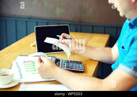 Owner of small business calculating bills and expenses with internet banking Stock Photo