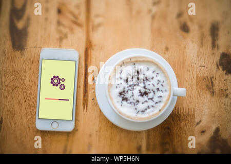 close-up top view of setting screen on mobile phone with a cup of coffee beside. All screen graphics are made up. Stock Photo