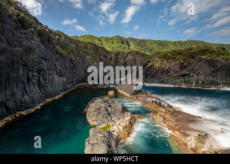 sunlight over the landscape at the Piscina Natural de Poça Simão Dias at the village of Fajã do Ouvidor, one of the most remarkable natural pools and Stock Photo