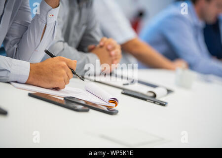 Man hand taking notes, Writting on a paper in a meeting at work Stock Photo