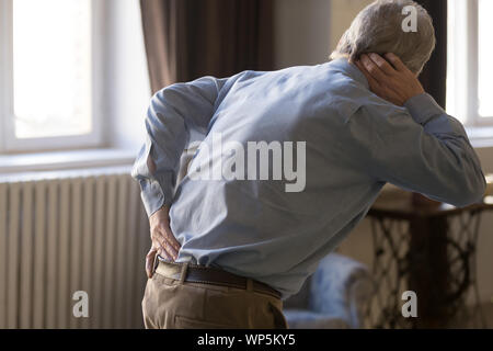 Hurt senior man touch back suffering from rheumatism Stock Photo
