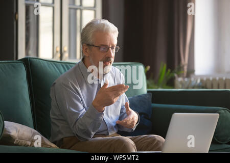 Mature man using computer connection having video call Stock Photo