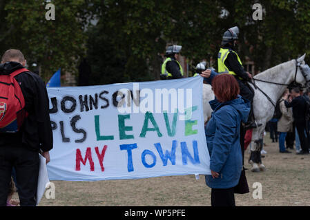 Protesters have gathered outside Parliament, demonstrating against Brexit and Prime Minister Boris Johnson's decision to suspend Parliament ahead of the Brexit date of 31 October. Many believe that the prorogue will allow the 'no deal' Brexit to proceed unopposed. Banner stating Johnson please leave my town Stock Photo