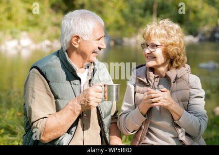 Happy mature active hikers with hot tea enjoying rest on sunny day Stock Photo