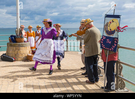 Swanage, Dorset UK. 7th September 2019. Crowds flock to the seaside town of Swanage to enjoy the dancing, with over 50 dance teams including morris dancing and clog dancing and the singing for Swanage Folk Festival. Beetlecrushers clog dancers perform on the pier. Credit: Carolyn Jenkins/Alamy Live News Stock Photo