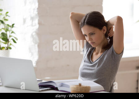 Focused girl student busy preparing for using laptop Stock Photo