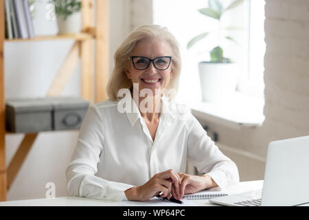 Portrait of smiling senior businesswoman posing at workplace Stock Photo