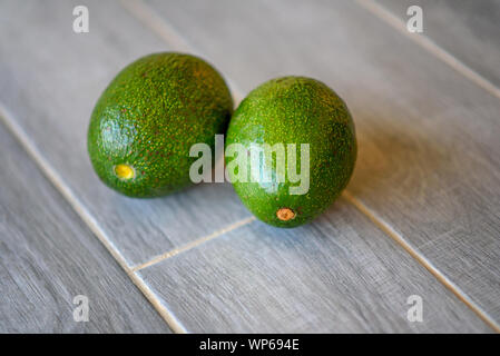 Two whole fresh avocado on gray background. Summer healthy eating concept. Top view, flat lay. Stock Photo