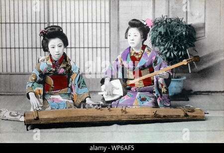 [ 1910s Japan - Japanese Women Playing Music ] —   Young Japanese women in kimono and traditional hairdo playing the koto (front) and the shamisen (back).  20th century vintage postcard. Stock Photo