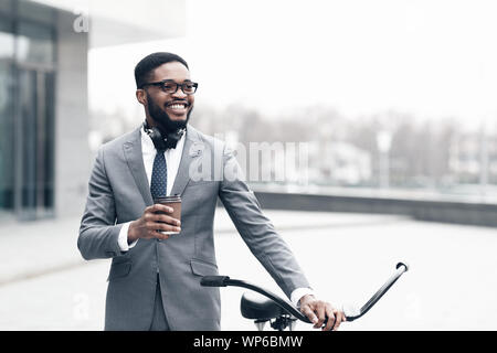 Young happy businessman going to work by bike Stock Photo