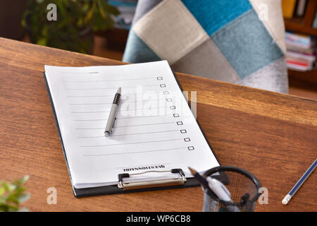 Questionnaire sheets in a folder on an office table and a pen on top. Horizontal composition. Elevated view. Stock Photo