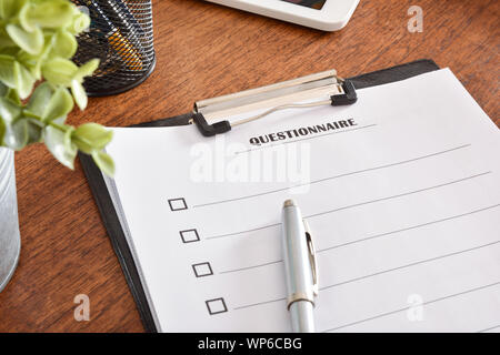 Questionnaire sheets in a folder on an office table and a pen on top. Horizontal composition. Top view. Stock Photo