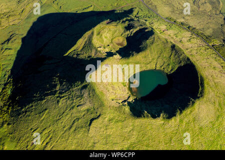 Aerial image of typical green volcanic caldera crater landscape with volcano cones of Planalto da Achada central plateau of Ilha do Pico Island, Azore Stock Photo