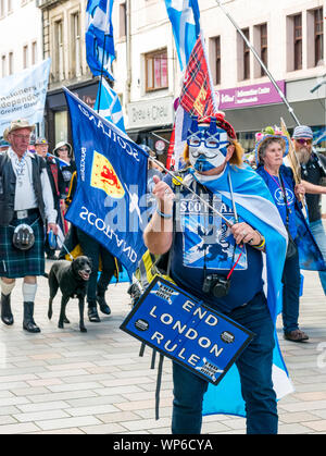 Perth, Scotland, United Kingdom, 7th September 2019. All Under One Banner Independence March: Independence supporters march through Perth in the 7th All Under One Banner (AUOB) march of this year. The march on the High Street. A man wearing a Guy Fawkes mask with an End London Rule sign Stock Photo