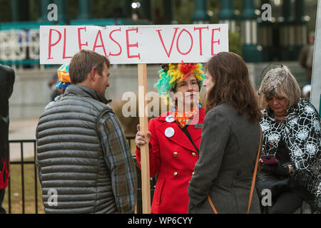 A woman wearing a rainbow wig holds a sign urging people to vote, at the Haints and Saints Halloween Parade on October 27, 2018 in Decatur, GA. Stock Photo