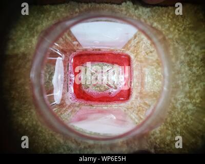 GUESS WHAT IT IS INSIDE FROM A BOTTLE NECK CLOSEUP MACRO VINTAGE TRANSPARENT JUICE BOTTLE FOR RECYCLING Stock Photo