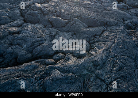 Detail of nice light at sunset over the black dark basalt coastline lava rocks of the westcoast of Ilha do Pico island, Azores Stock Photo