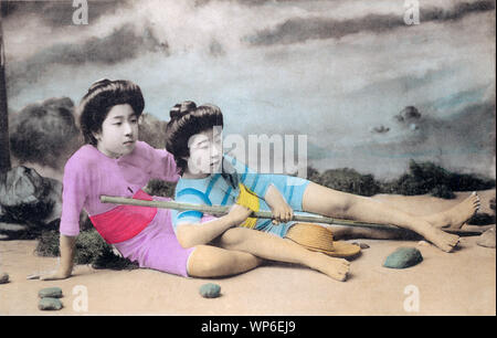 [ 1910s Japan - Japanese Women in Bathing Suit ] —   A studio photo of two young women with traditional hair styles posing in bathing suits. Models for these kind of photos were almost always geisha.  20th century vintage postcard. Stock Photo