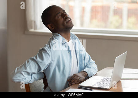 Hurt biracial man suffer from lower back pain Stock Photo