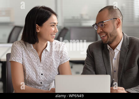 Happy mixed race employees working together at office. Stock Photo