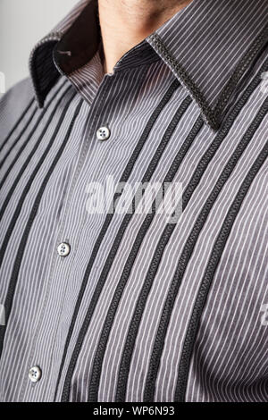 Close up of man's woven fabric dress shirt. Men's clothing fashion apparel. Selective focus on embroidery top-stitching finishing details. Stock Photo