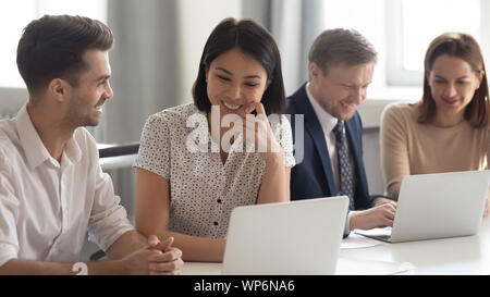 Happy mixed race coworkers working in groups on projects. Stock Photo