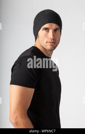 Man wearing black t-shirt and knit hat. Young men's modern casual clothing fashions styles. Stock Photo