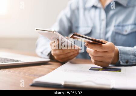 Businesswoman paying her bills online using application in smartphone Stock Photo