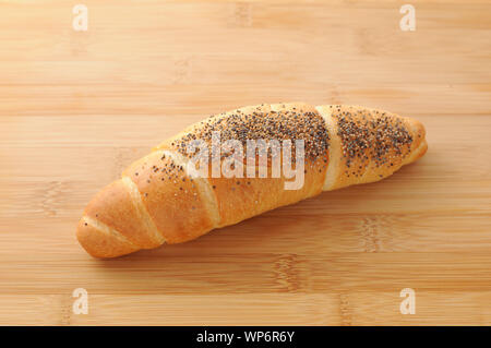 Mini French bread baguette with sesame seeds closeup isolated on cutting board Stock Photo