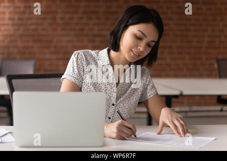 Smiling asian female executive manager signing business contract. Stock Photo