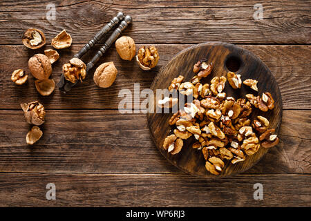 Walnuts. Kernels and whole nuts on wooden rustic table, top view Stock Photo