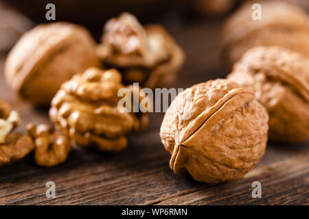 Walnuts. Kernels and whole nuts on wooden rustic table Stock Photo