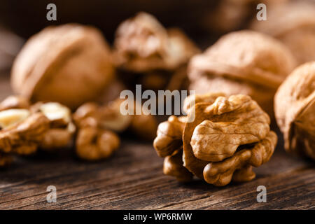 Walnuts. Kernels and whole nuts on wooden rustic table Stock Photo