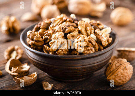 Walnuts. Kernels and whole nuts on wooden rustic table Stock Photo