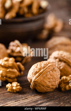 Walnuts. Kernels and whole nuts on wooden rustic table Stock Photo