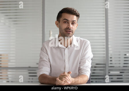 Concentrated male hr manager holding video distant job interview. Stock Photo