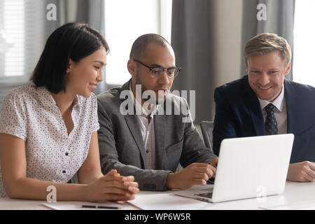 Successful smiling diverse colleagues listening to african american team leader. Stock Photo
