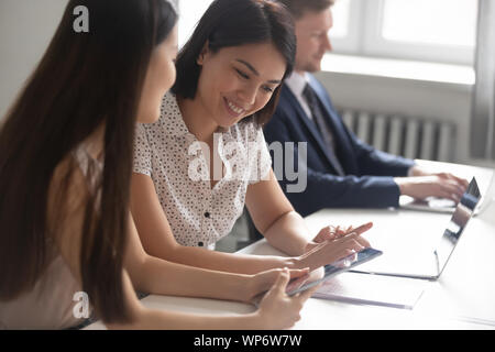 Confident asian mentor helping korean intern or new worker. Stock Photo