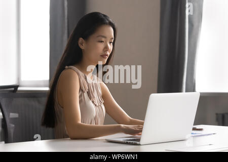 Confident asian young business woman working with computer at office. Stock Photo